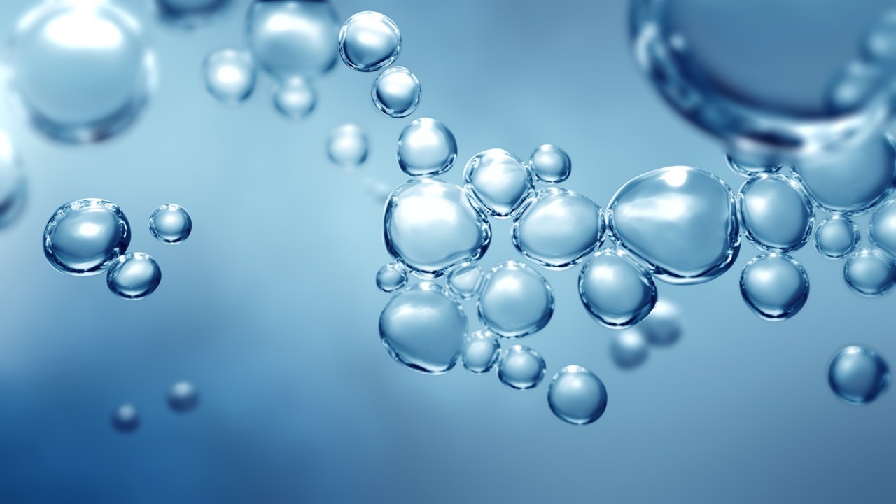 Bubbling fizz and refreshing beauty care products cleanliness or reviving vitality. Studio shot of transparent effervescent blue gas bubbles levitating in macroscopic view with defocus bokeh blur.